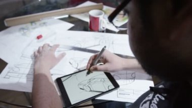 Otomotiv tasarım çizimleri ile tablet kullanan adam