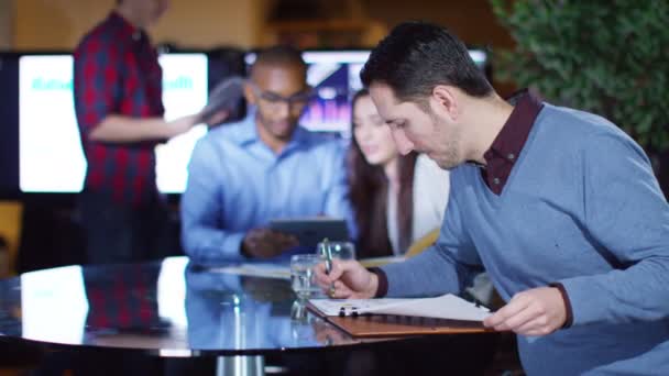 Businessman sitting with colleagues in office — Wideo stockowe