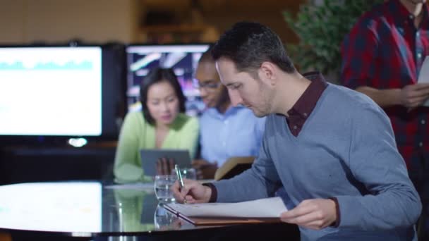 Businessman sitting with colleagues in office — Wideo stockowe