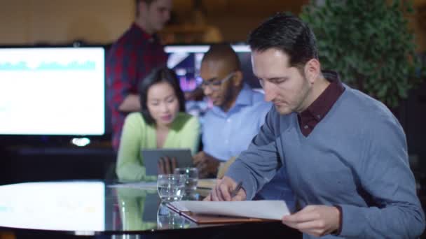Бізнесмен сидить з колегами в офісі — стокове відео