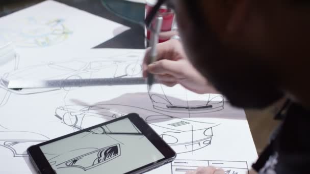 Automotive designer med tablett med konstruktionsritningar — Stockvideo