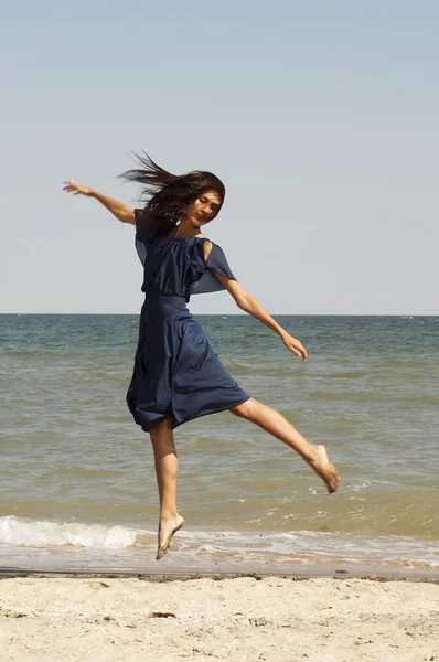 Young beautiful woman on the beach jumping — Stock Photo, Image