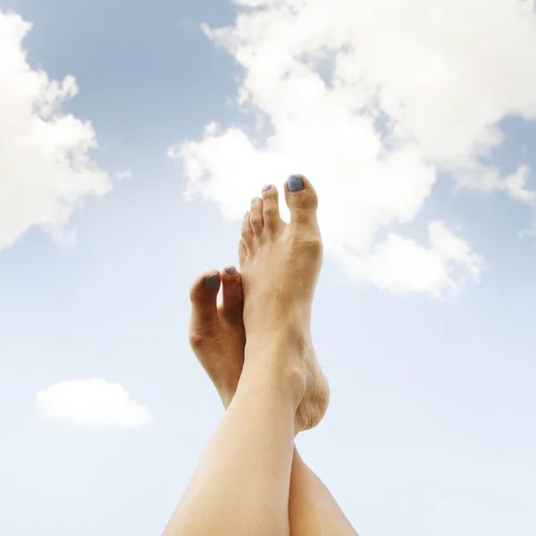 Picture of pretty woman's leg over the blue sky in the field of — Stock Photo, Image