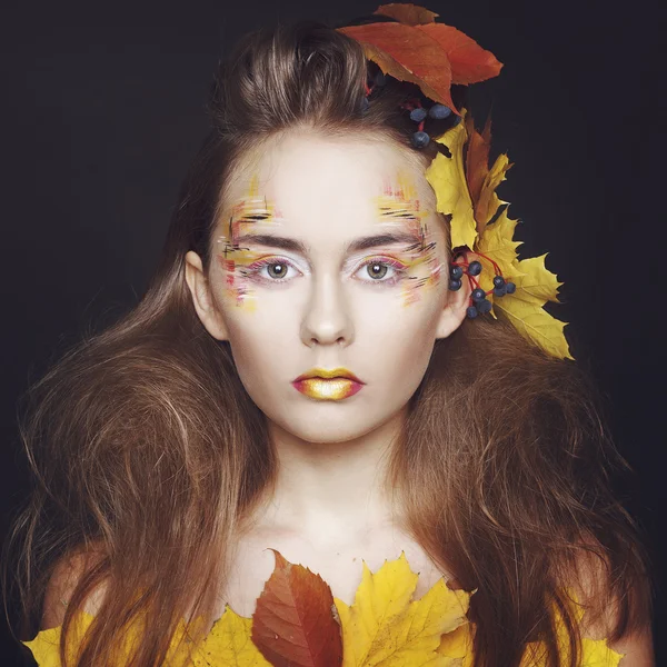 Mujer joven con maquillaje de otoño y hojas en la cabeza — Foto de Stock