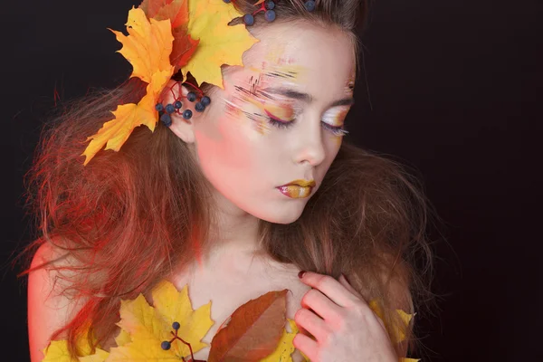 Giovane donna con trucco autunnale e foglie sulla testa — Foto Stock