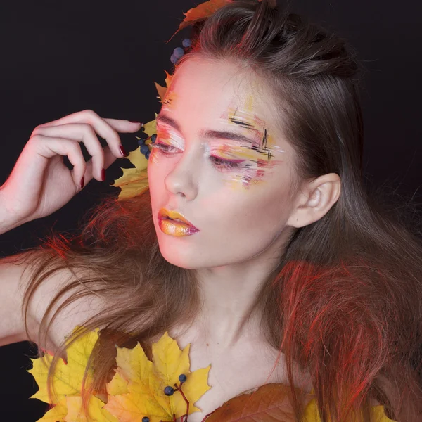 Young woman with autumn make up and leaves on head and her body — Stock Photo, Image