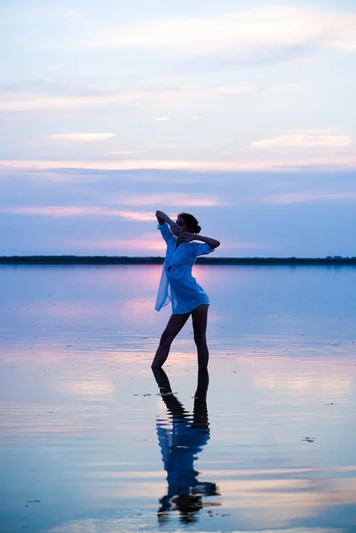 Mooie jongedame in de zee bij zonsondergang — Stockfoto