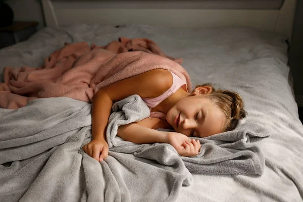 昼間はピンクのパジャマを着た可愛い女の子が彼女の悪いところで寝ていた 健康的なライフスタイルのコンセプト — ストック写真