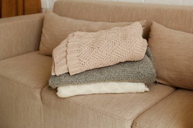 Üzerinde gri battaniye olan gri rahat bir kanepe resmi.