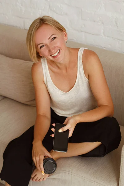 Молодая Красивая Блондинка Разговаривает Мобильным Телефоном Сидя Светлой Гостиной Фрилансер — стоковое фото