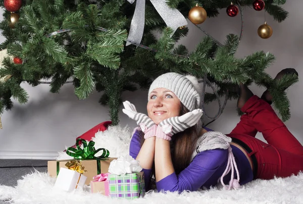 Молодая красивая женщина возле новогодней елки с подарком — стоковое фото