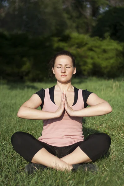 Mujer joven haciendo yoga al aire libre — Foto de Stock