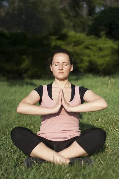 Dışarıda yoga yapan genç bir kadın. — Stok fotoğraf