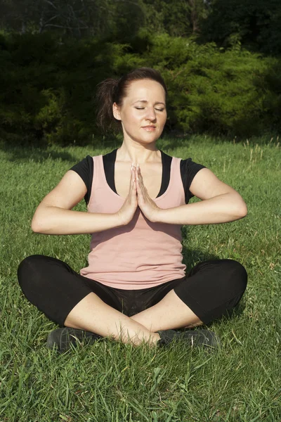 Dışarıda yoga yapan genç bir kadın. — Stok fotoğraf