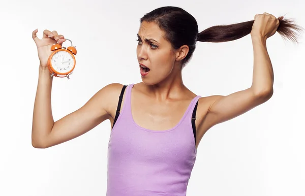 Young shocked woman holding clocks in hands — Stock Photo, Image