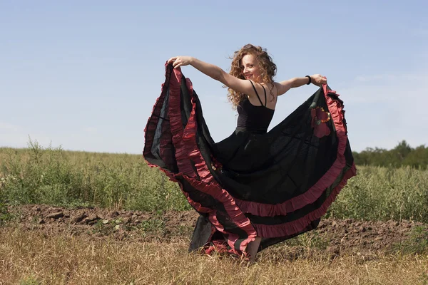 Jonge vrouw dansen buitenshuis in lange rok — Stockfoto