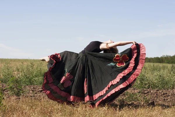 Jonge vrouw dansen buitenshuis in lange rok — Stockfoto