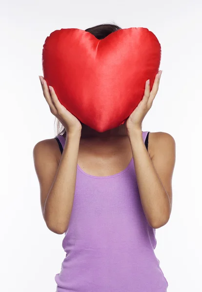 Vrouw houdt hart kussen — Stockfoto