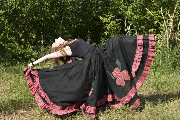 Jonge vrouw dansen buitenshuis in lange rok — Stockfoto