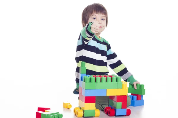 Malý chlapec hraje lego a ukazuje rukou ok znamení — Stock fotografie