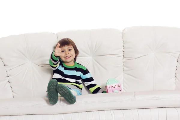 Kleine jongen zittend op de Bank met speelgoed huis weergegeven: hand ok si — Stockfoto