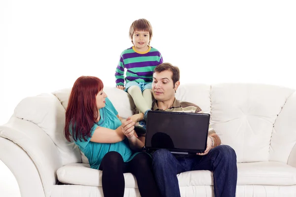 Far, mor og søn sidder på sofaen med notesbog - Stock-foto