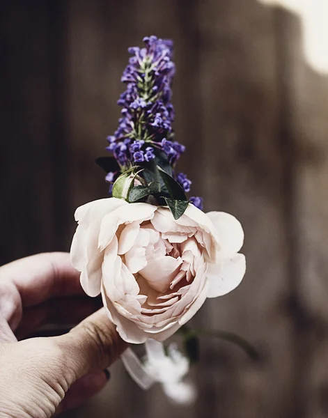 Picture of beautiful boutonniere of rose in woman's hands — Stock Photo, Image