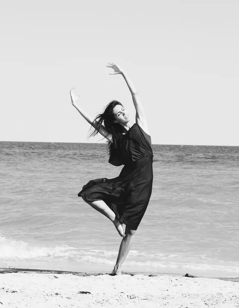 Mooie jonge vrouw dansen op het strand — Stockfoto