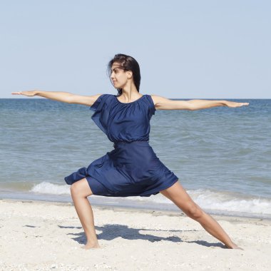 Deniz mavi elbiseli, yoga yaparken genç güzel kadın