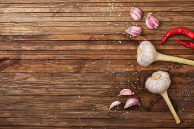 İki baş baharatlı sarımsak ve ahşap desenli mutfak masasında karanfilleri.