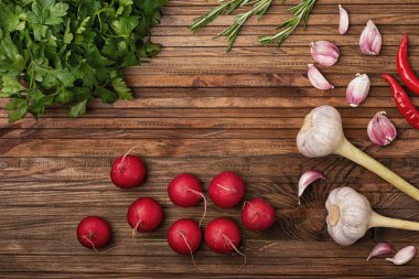 Biberiye, turp, sarımsak, maydanoz, mikro yeşil, mutfak masasına serilmiş.