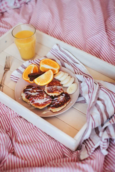 breakfast in bed, pancakes with fruit and juice on a tray