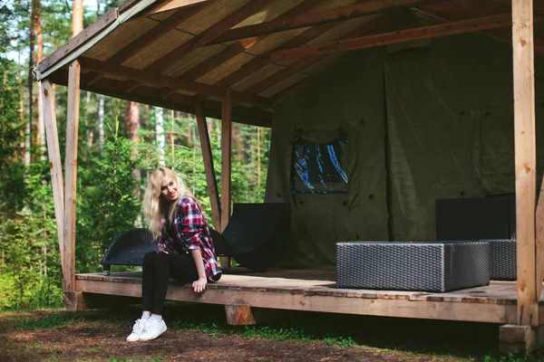 girl sitting in a large tent in the woods