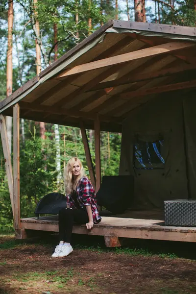 girl sitting in a large tent in the woods