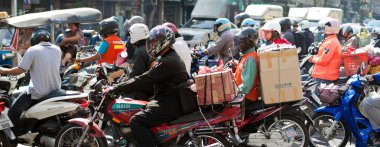 Motorcyclists wait at a junction during rush hour in Bangkok, Thailand clipart