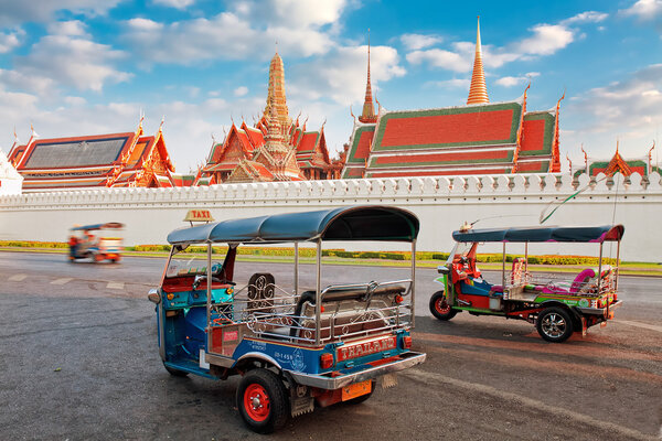 Tuk Tuk taxi waits for customers about Temple of Emerald Buddha and home of Thai King in Bangkok