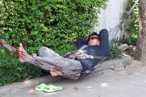 Taets vilar i en hängmatta på gatorna i Bangkok. Thailand — Stockfoto