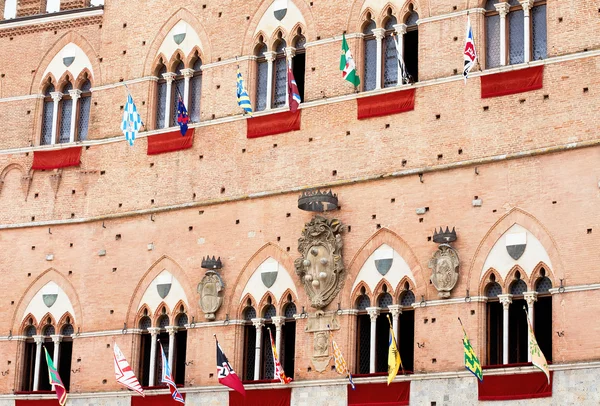 Banderas de Contrada en el edificio del ayuntamiento en la plaza medieval "Piazza del Campo " — Foto de Stock