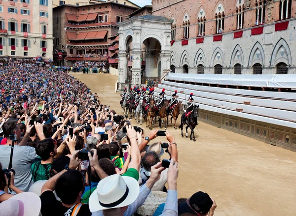 Performance of cavalry on parade before start of annual traditional Palio di Siena horse race in medieval square "Piazza del Campo" — Stock Photo, Image