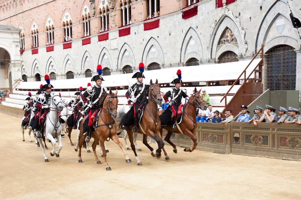 Prestaties van cavalerie op parade voor aanvang van de jaarlijkse traditionele Palio van Siena paardenrace in middeleeuwse plein 'Piazza del Campo" — Stockfoto