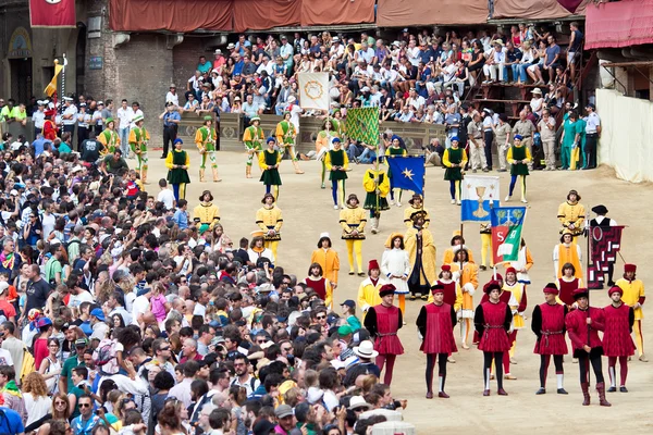 Desfile antes do início da tradicional corrida anual de cavalos Palio di Siena na praça medieval "Piazza del Campo " — Fotografia de Stock