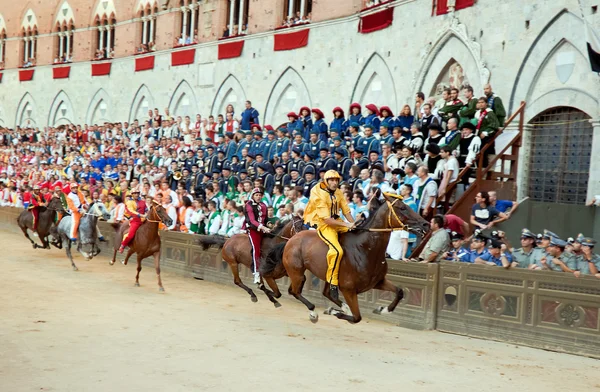 Renners concurreren in paardenrennen "Palio di Siena" in het middeleeuwse plein "Piazza del Campo" — Stockfoto