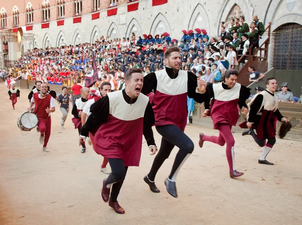 Οι θαυμαστές χαροποίησε το νικητή του αγώνα στην ετήσια παραδοσιακή ιπποδρομία του παλιό Ντι Σιένα στη μεσαιωνική πλατεία "Piazza del Campo — Φωτογραφία Αρχείου