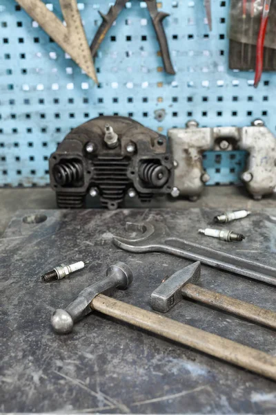 Motoristas no local de trabalho. Ferramentas antigas montadas em mesa metálica com ferramentas e autopeças — Fotografia de Stock