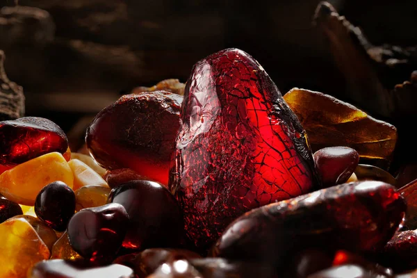 Beleza de âmbar natural. Várias pedras âmbar naturais vermelhas escuras em uma caverna. — Fotografia de Stock