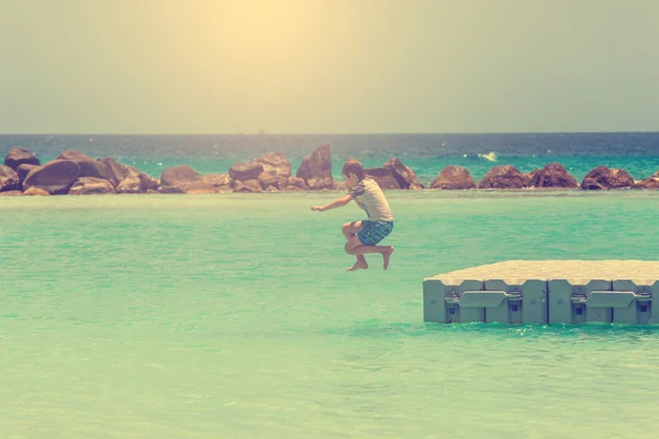 Мальчик прыгает в море — стоковое фото