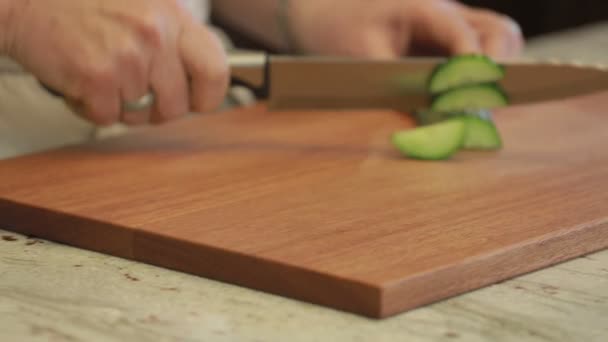 Pepino rebanado en una tabla de cortar con un cuchillo — Vídeos de Stock