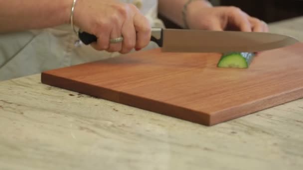 Pepino sendo cortado em uma tábua de corte com uma faca — Vídeo de Stock