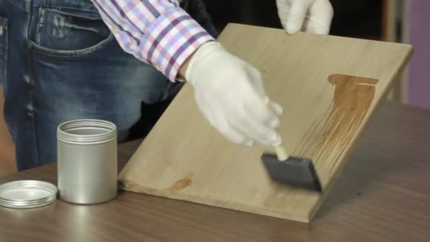 Hombre en guantes blancos barnices tablero de madera — Vídeos de Stock