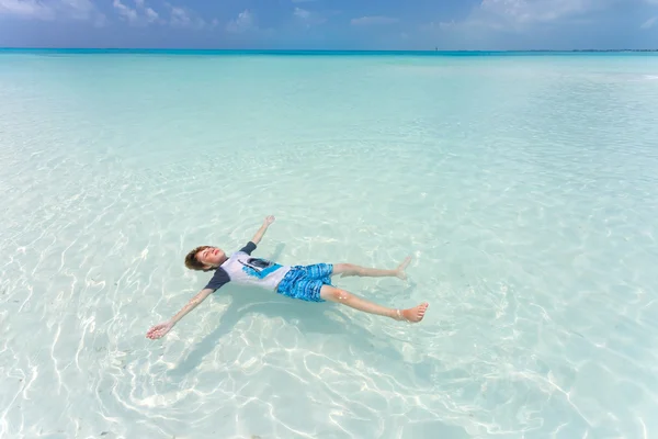 Ребенок плавает на спине в красивом море — стоковое фото